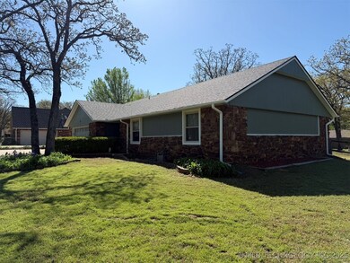 View of side of property with stone siding, a yard