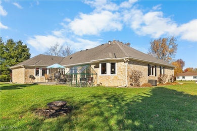 Back of house with a yard, brick siding, and an outdoor fire pit