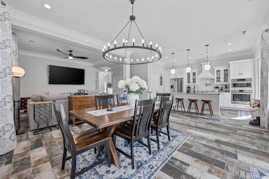 Dining room featuring ceiling fan, recessed lighting, ornamental molding, and a chandelier