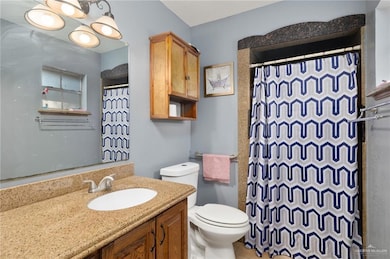 Full bath with a shower with curtain and vanity