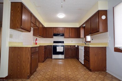 Plenty of oak cabinets, counters, and appliances s