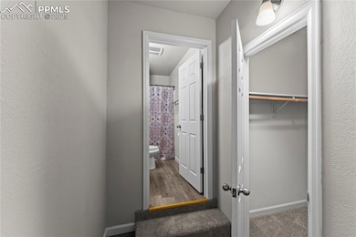 Hallway featuring wood finished floors and a textured wall