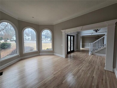 Spare room with hardwood / wood-style floors, a notable chandelier, and ornamental molding