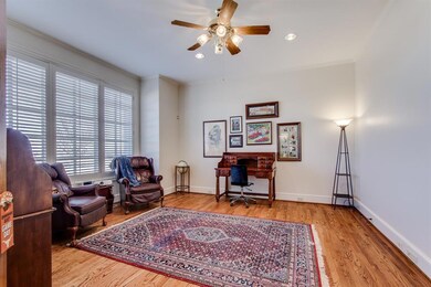 The wall of windows bring in loads of light into this den now being used as a shared office.