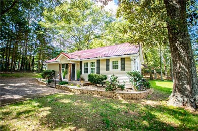 Single story home featuring a metal roof and a front yard