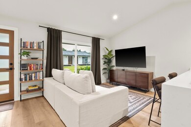 Living room featuring lofted ceiling, light wood-