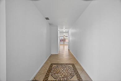 Corridor featuring inlaid floor details and light tile patterned flooring