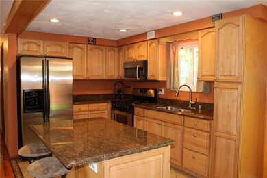 Fully equipped eat-in kitchen with maple cabinets,