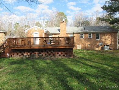 Back of property with a yard and a deck