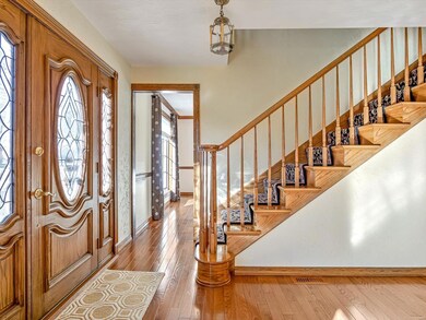 Entryway displaying beautiful wood stairs and floo