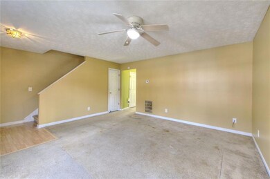 Empty room with baseboards, carpet, stairs, a text