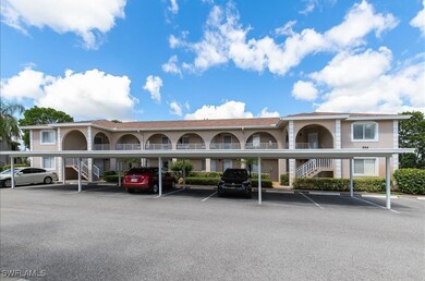 View of property featuring stairs and covered parking