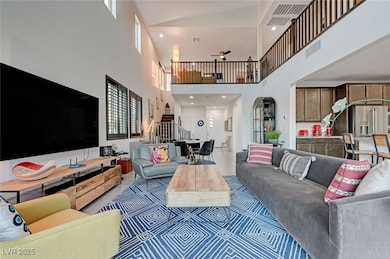 Living area featuring a towering ceiling, stairway