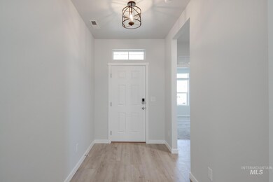 Entrance foyer with light wood-style flooring and a chandelier