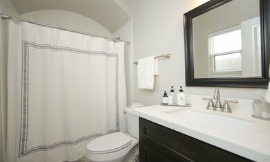 The ensuite bathroom has quartz countertops and a