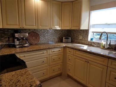 Kitchen features custom cabinets, granite counters
