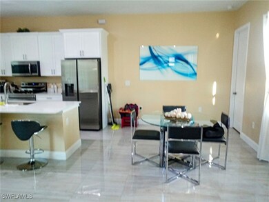 Kitchen featuring baseboards, a kitchen bar, light