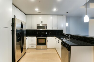 Kitchen with dark stone countertops, stainless st