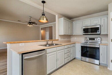 Kitchen featuring pendant lighting, white cabinets, kitchen peninsula, appliances with stainless steel finishes, and ceiling fan