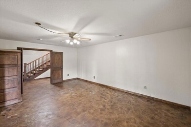 Empty room featuring ceiling fan and a textured ce