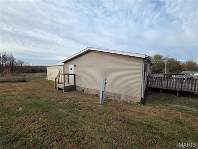 View of side of home with a lawn and a deck