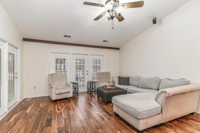 Living room featuring french doors, ceiling fan, dark hardwood / wood-style flooring, and lofted ceiling