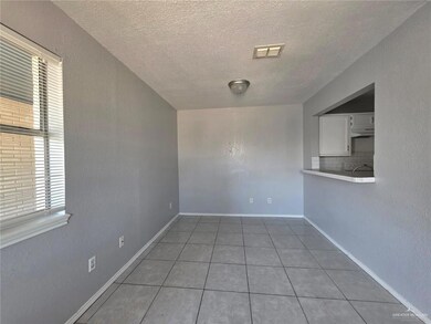 Empty room featuring a wealth of natural light, visible vents, a textured ceiling, and light tile patterned flooring