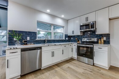 Kitchen with tasteful backsplash, appliances with 
