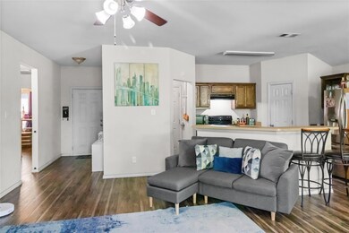 Living room featuring ceiling fan and dark hardwoo