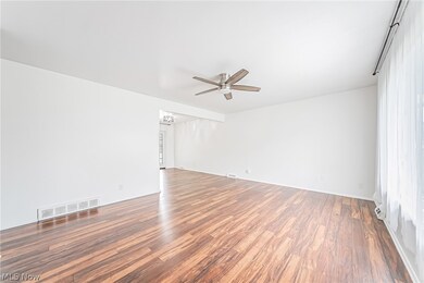 Empty room with hardwood / wood-style flooring and ceiling fan