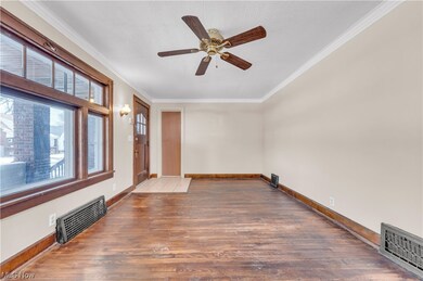 Unfurnished room with dark wood-type flooring, ceiling fan, and ornamental molding