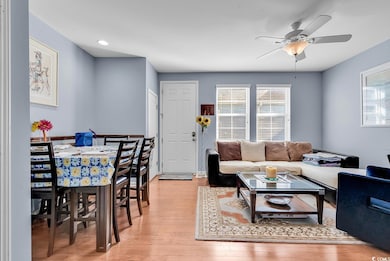 Living room/dining area with light wood-type flooring, ceiling fan, and recessed lighting