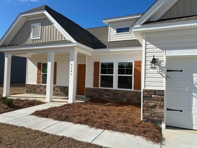 View of exterior entry with stone siding, covered 