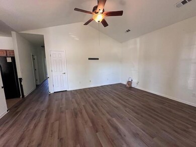 Empty room with a ceiling fan, dark wood-style flooring, and high vaulted ceiling