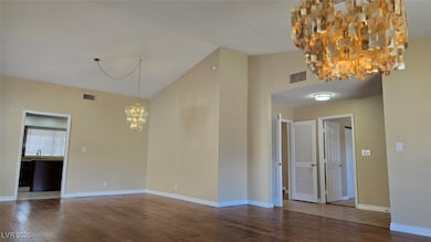 Spare room with a notable chandelier, wood finishe