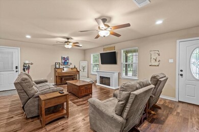 Living room with ceiling fan and wood-type floorin