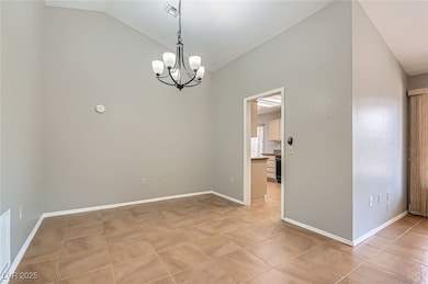 Unfurnished room with lofted ceiling, a chandelier