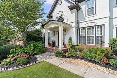 Doorway to property featuring stucco siding, covered porch, a yard, and brick siding