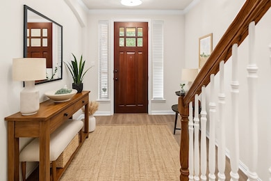 Virtually Staged Entrance foyer featuring ornamental molding, light wood-style floors, and stairway
