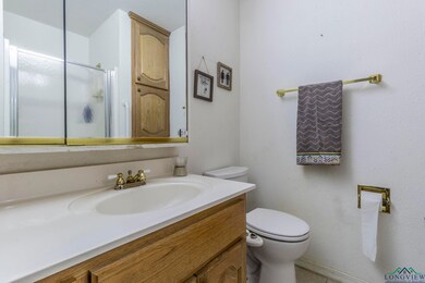 Bathroom with toilet, vanity, and a shower with do