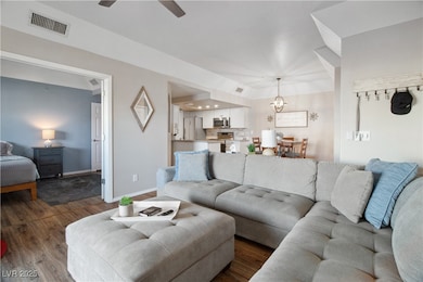 Living room with dual door entry into the Second Bedroom. The Dining Area and Kitchen are also pictured.