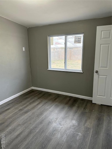 Unfurnished room featuring dark wood-style floors