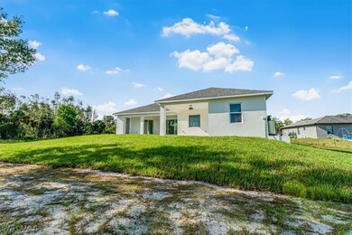 Back of property featuring stucco siding and a yar