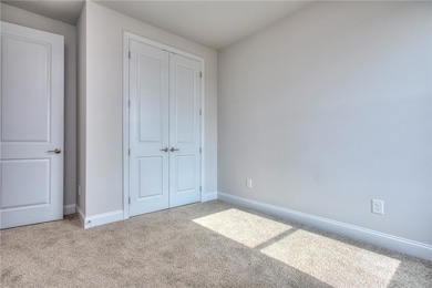 Unfurnished bedroom with a closet, carpet, and baseboards