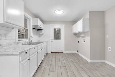 Washroom with wood finish floors, washer hookup, cabinet space, and hookup for an electric dryer