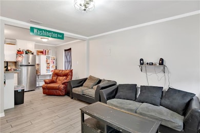 Living area with light wood-style flooring and ornamental molding