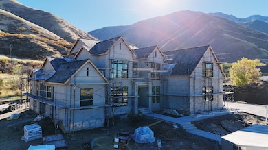 View of front of home with a mountain view, roof with shingles, and stucco siding