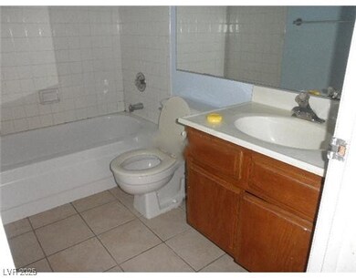 Full bath featuring light tile patterned floors, vanity, and washtub / shower combination