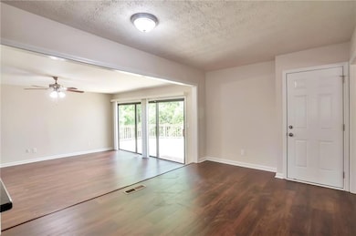 Empty room featuring dark wood-style flooring, a t