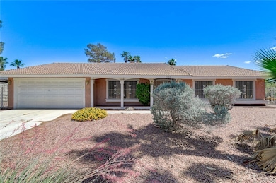 Ranch-style house featuring a tiled roof, a garage
